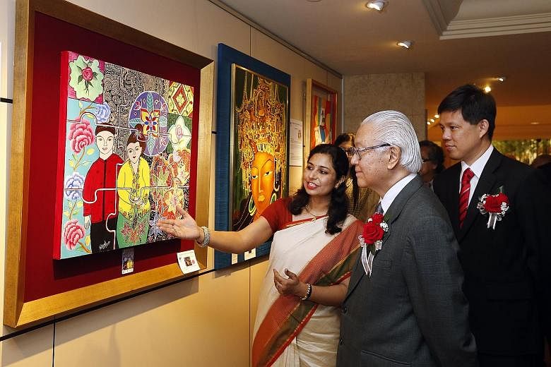 Artist Shivali Mathur showing President Tony Tan Keng Yam the painting Integration, which she says is a representation of the way that culture "comes together as one" in Singapore. With them is Minister in the Prime Minister's Office Chan Chun Sing.