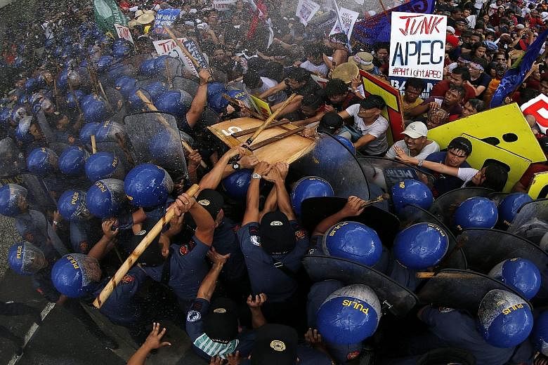 Activists clashing with police in Manila on Thursday. Apec has been slammed as nothing more than a peripatetic photo-op, with "family photos" of Apec leaders dressed in the host country's national dress.