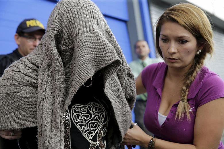 Migration police escorting a Syrian woman after she was detained in San Jose, the capital of Costa Rica, on Thursday. The woman arrived in the Central American country with a Greek passport, the foreign ministry said.