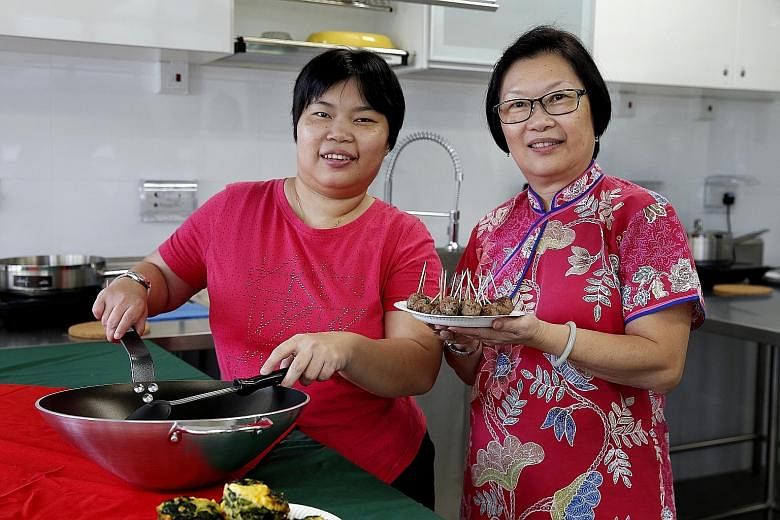Ms Mabel Thang (far left), who has mild intellectual disability and left hemiplegia which limits her movements, with her mother Jenny in Agape Village's cooking training room. Ms Thang attends cooking classes, yoga lessons and art and craft classes a