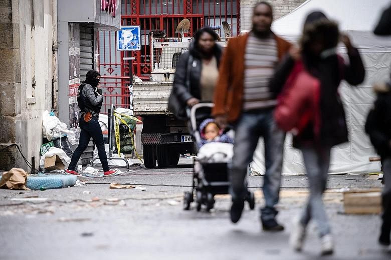 Residents walking near a rue du Corbillon building in Saint Denis, a northern Paris suburb, on Thursday. French police launched a raid in the suburb early on Wednesday in connection with the Nov 13 terrorist attacks.