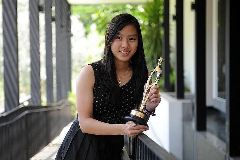 National badminton player Yeo Jia Min posing with The Straits Times' Star of the Month award for October. Her title wins (both singles and doubles) at the Badminton Asia Under-17 tournament won her the accolade.