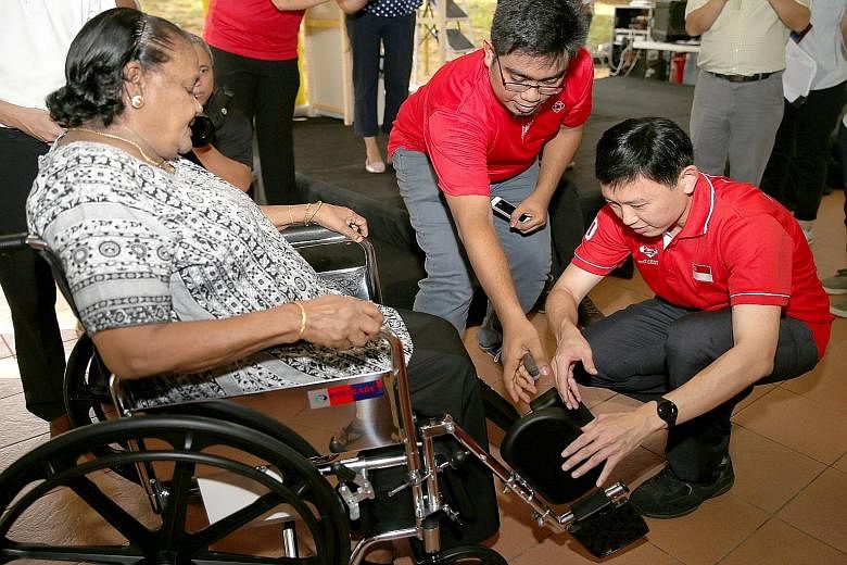 Mr Chee Hong Tat (right), an MP for Bishan-Toa Payoh GRC, helping Toa Payoh resident Paruvadi Duraisamy, 84, with her borrowed wheelchair.