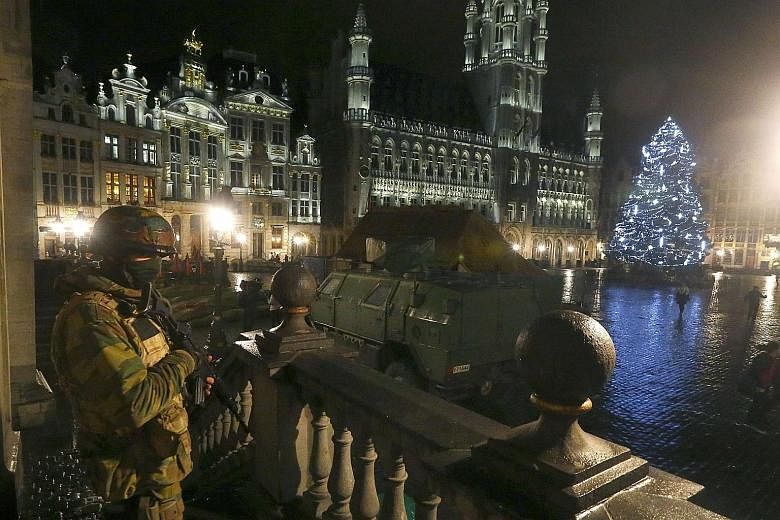 A Belgian soldier standing guard over the Grand-Place of Brussels as police searched the area on Sunday following the recent deadly Paris attacks. Armed police and troops have been patrolling the near- deserted streets of Brussels all weekend after t