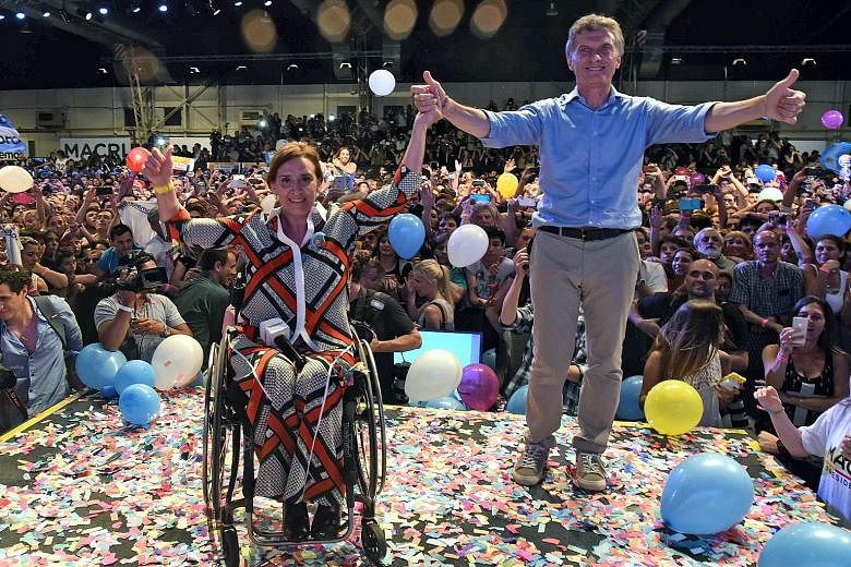 Mr Mauricio Macri and his running mate, Ms Gabriela Michetti (who has to use a wheelchair after being seriously injured in a car accident in 1994), celebrating in Buenos Aires on Sunday, after getting early results of the presidential run-off electio