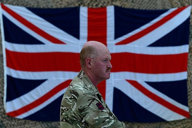 A British military officer in front of the Union Jack. Prime Minister David Cameron was to present the full £178 billion (S$383 billion) spending plan for the British military over the next decade in Parliament yesterday.