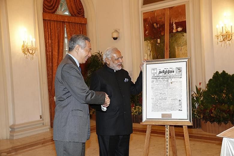 Mr Modi calling on President Tony Tan Keng Yam at the Istana yesterday. (Right) Mr Lee presenting a special gift of the front page of Tamil Murasu dated Aug 11, 1965, to Mr Modi. It carries the news of India officially recognising the then newly inde