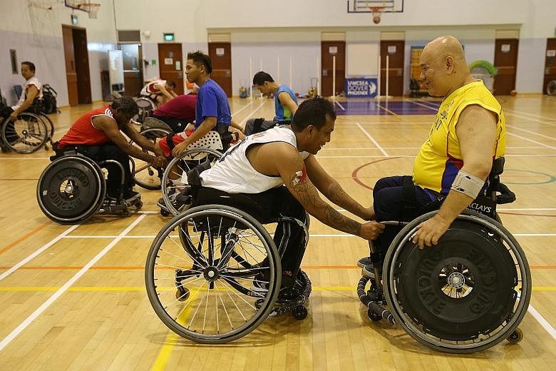 Mr Ng Chong Ping, 42, tries to shield the ball from volunteers Jeannette Leung (left), 25, and Nur Sahira, 24. The team train with a group of able-bodied volunteers, who prove to be tough opponents. Above: Mr Kamas Mohd, 44, gets a rebound while play
