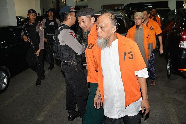 Muhammad Basri (front) and other terror suspects arriving for their trial on Oct 20. They are said to have links with ISIS.