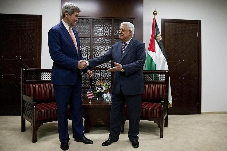 Mr John Kerry (left) meets Mr Mahmoud Abbas upon his arrival in the West Bank city of Ramallah on Tuesday.