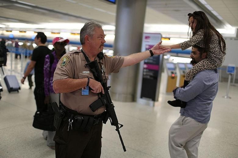 An officer on patrol at Miami International Airport. Many Americans are going ahead with their holiday plans.
