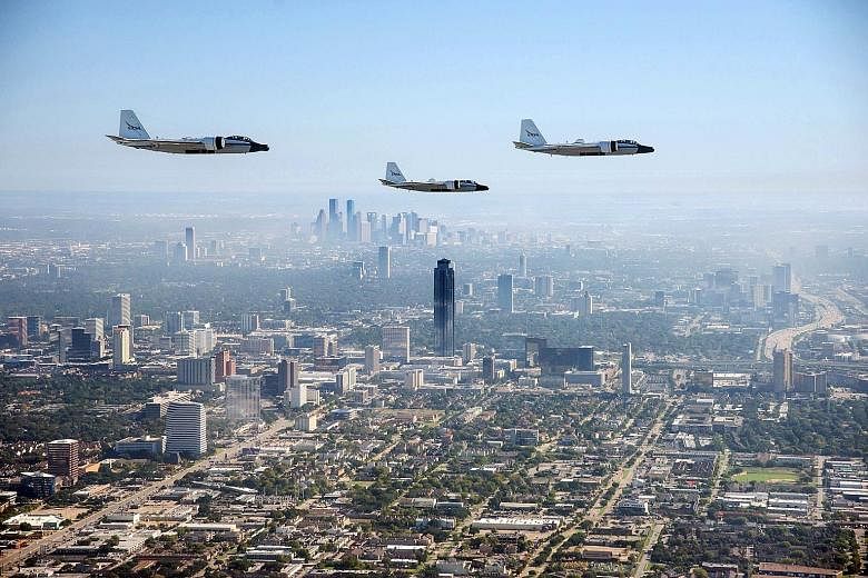 A Nasa handout shows the last three airworthy WB-57 aircraft photographed from a Navy T-6 aircraft while flying in formation over Houston, Texas, and the Johnson Space Centre last week for a historic photo flight. The WB-57s have been flying high-alt