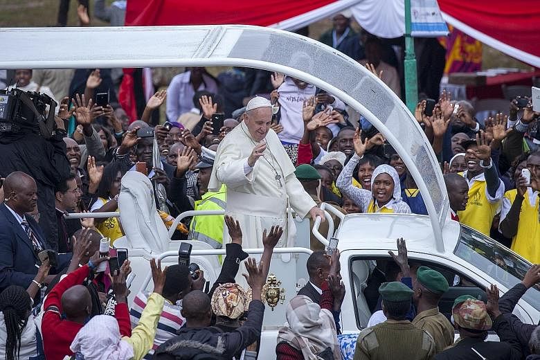 Pope Francis waving to the crowd at the University of Nairobi in Kenya, as he arrived yesterday to conduct an open-air mass for tens of thousands of people. Bridging divisions between Muslims and Christians is a main theme of the Pope's first tour of