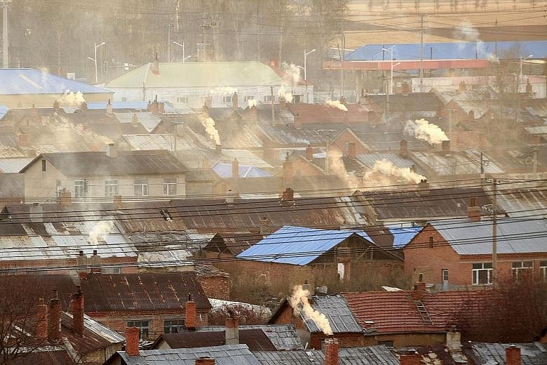Chimneys of houses in Heihe, in north-eastern China's Heilongjiang province, spewing smoke. China, the US and the EU - some of the biggest emitters - have pledged contributions towards reducing greenhouse gas emissions, as have many other countries.