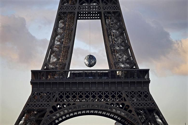 Artwork Earth Crisis by American artist Shepard Fairey is suspended at the Eiffel Tower in Paris, France. The capital will host the World Climate Change Conference 2015 from Nov 30 to Dec 11.