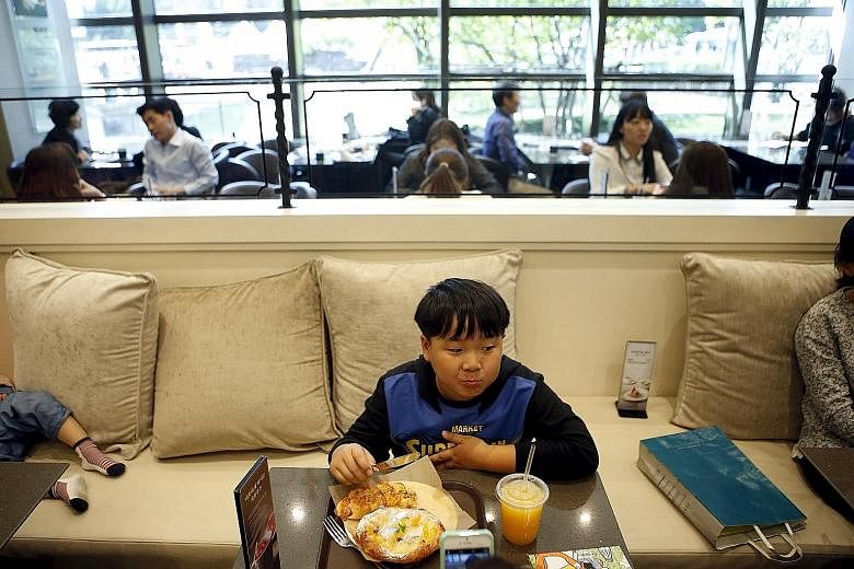 A boy eating bread at an eatery in Seoul. The nation's per capita flour consumption registered a high of 33.6kg last year - slightly over half of the 65.1kg for rice.