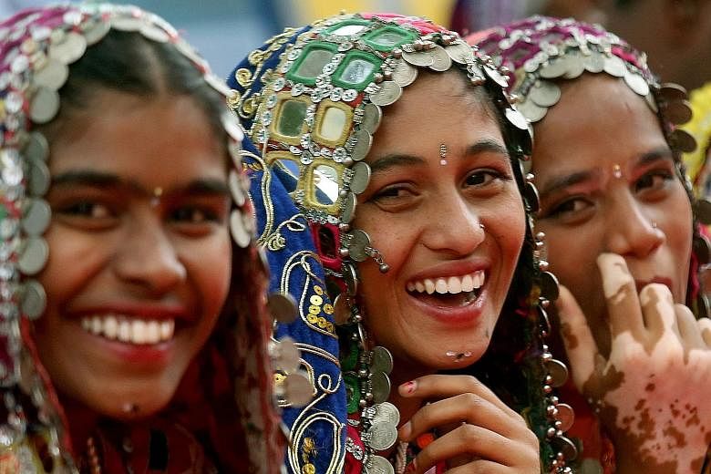 Indian school girls wearing tribal costumes at a Children's Day celebration in Bangalore. New discoveries point to fresh ways of thinking about happiness.