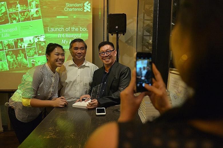 Mr Wong Kim Hoh (right) with one of his interviewees, Mr Toh Chin Siong, a used furniture salesman, and his daughter Brillyn at the launch of It Changed My Life at The Straits Wine Company, UE Square, last week. The book is a collection of 39 stories