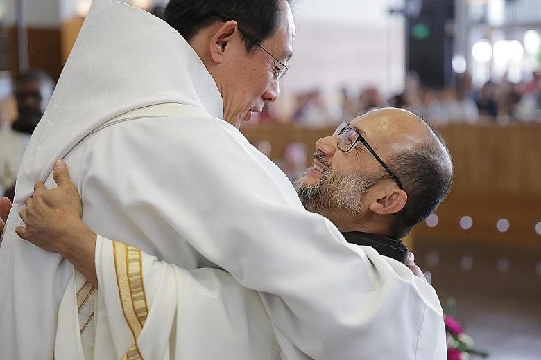 Above: Father Rowland Yeo, 58, (right) hugging Father John-Paul Tan, Order of Friars Minor, Chancellor (Chancery of the Roman Catholic Archdiocese of Singapore), after he was ordained a priest yesterday. Left: Father Yeo built tables and chairs in hi