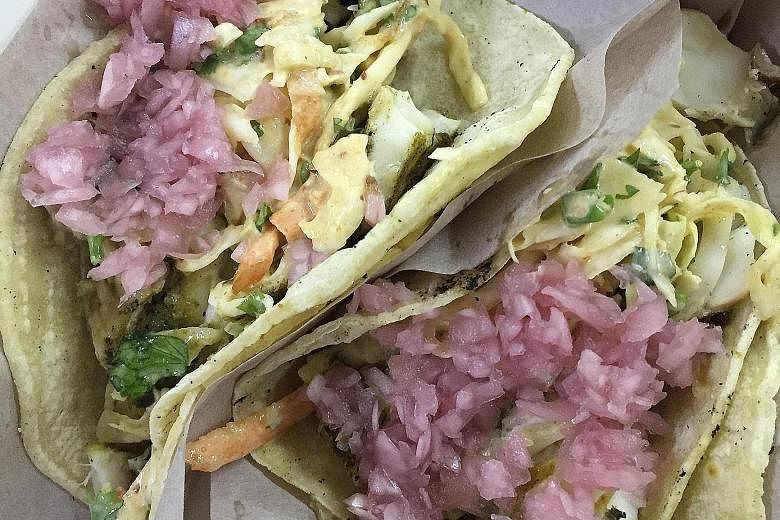 The fish tacos are filled with juicy tilapia chunks topped with pickled onions and slaw.