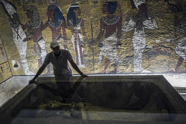 An archaeologist with the sarcophagus of King Tutankhamun in his mausoleum. "We are saying now it's 90 per cent likely there is something behind the walls," said Egypt's antiquities minister.
