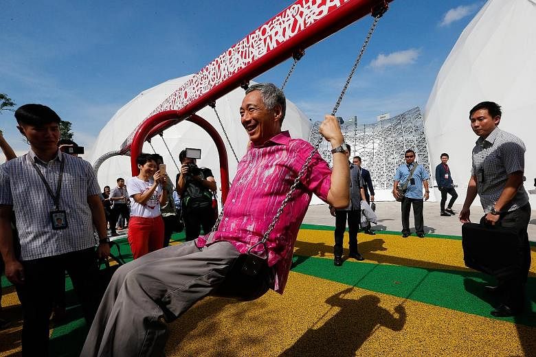 PM Lee Hsien Loong trying out a swing yesterday at one of the stations after launching the Future Of Us exhibition, which caps the year-long SG50 Golden Jubilee celebrations.