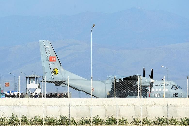 The coffin of the pilot killed when Turkey shot down a Russian warplane being carried to a Turkish aircraft at Hatay Airport in the southern Turkish province of Hatay, in preparation for its return to Russia.