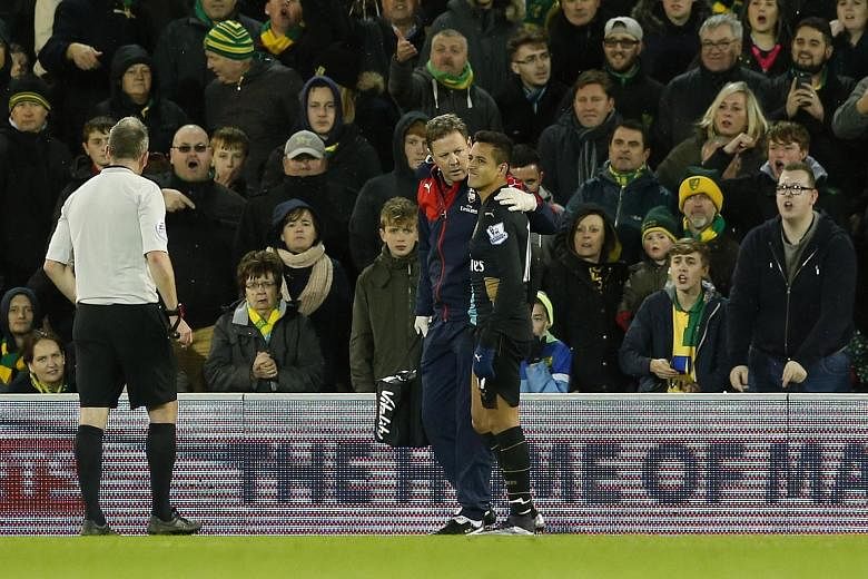 Arsenal's Chilean forward Alexis Sanchez going off injured in the 1-1 draw against Norwich on Sunday. Laurent Koscielny and Santi Cazorla also hurt their hip and knee respectively.