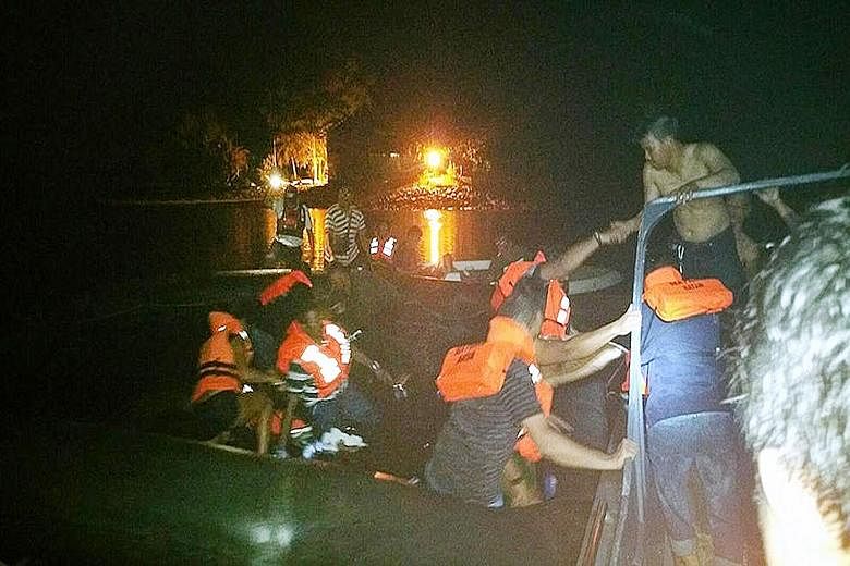 Passengers of a Singapore-bound ferry from Batam, who were evacuated after the vessel hit a floating object, being helped by villagers after water began entering their lifeboat. The villagers came to the rescue on Sunday night, after 97 people were e