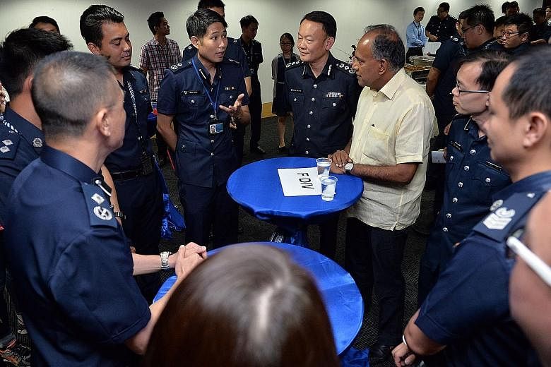 Home Affairs Minister K. Shanmugam chatting with police officers at the tea reception at Police Cantonment Complex yesterday. With him are Commander of Ang Mo Kio Division Lian Ghim Hua (2nd from right), Commissioner of Police Hoong Wee Teck (4th fro