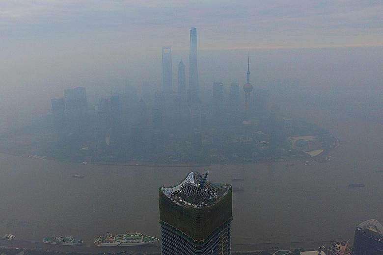 The Shanghai Pudong Lujiazui area shrouded in thick smog yesterday. In Beijing, the high smog level triggered an orange-level pollution alert over the weekend, with residents advised to stay indoors and some factories ordered shut.