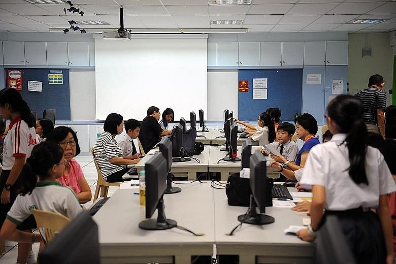 Seniors picking up computer skills at a school under a learning programme that pairs students with older learners. The latest report by the International Telecommunication Union says Singapore's ranking was pulled down by its adult literacy rate, and
