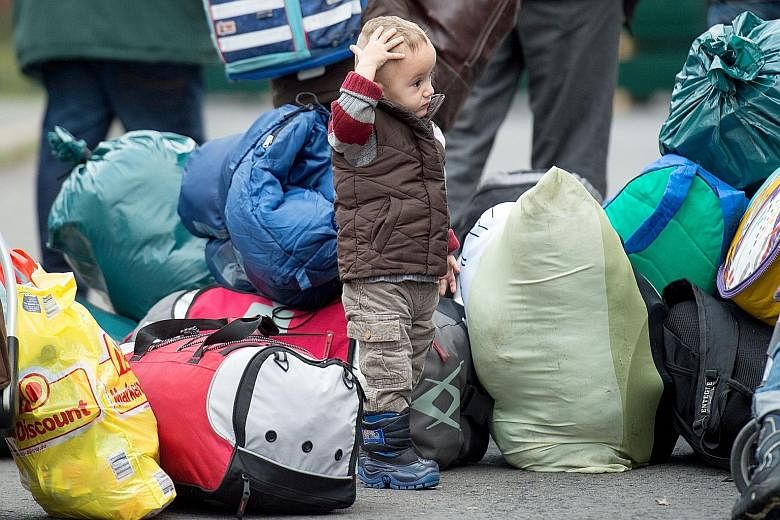 A bewildered boy at a first registration centre for refugees in Germany yesterday. Berlin and Paris support a quota system to redistribute migrants across EU members.