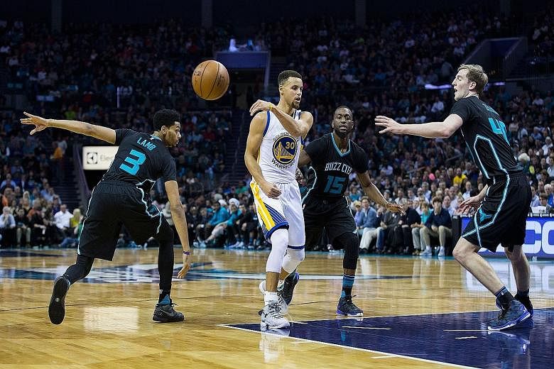 Stephen Curry (30) making a no look pass as Jeremy Lamb (3), Kemba Walker (15) and Cody Zeller (40) take him on.