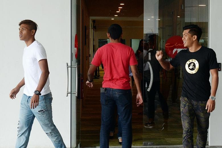 LionsXII half-brothers Khairul Nizam (left) and Khairul Amri leaving yesterday's meeting. The FAS has assured the bulk of LionsXII players that they will be guaranteed contracts on the same salaries next year.