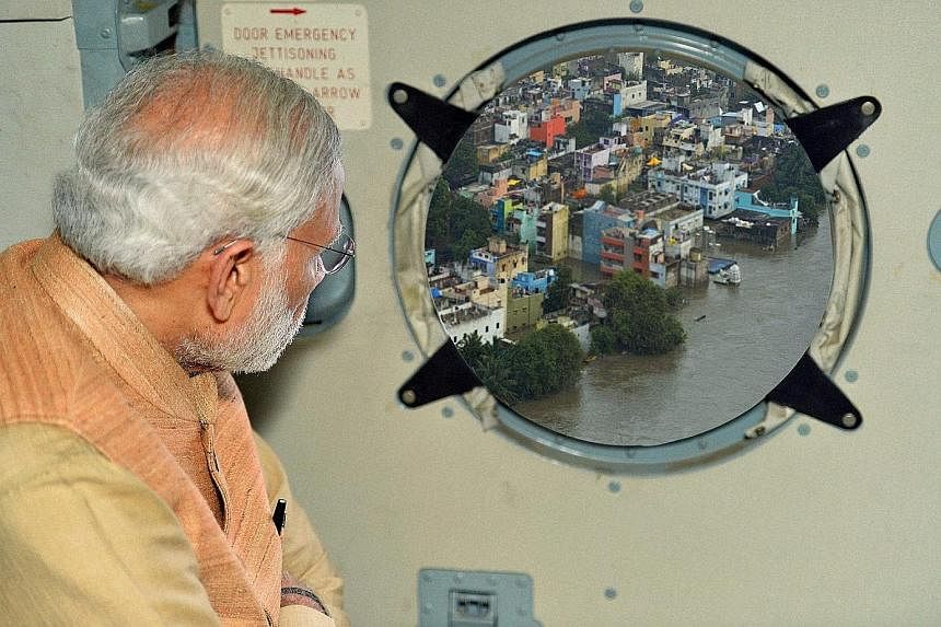 An undoctored photograph (top left) showing Prime Minister Narendra Modi surveying an area of rain-hit Chennai was posted on his Twitter feed. The Press Information Bureau also published on its website a similar photo (bottom) with a much clearer ima