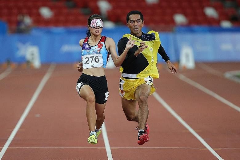Thailand's Wannaruemon Kewalin running alongside her guide as she is visually impaired. The 21-year-old broke the Games record in the women's 100m T11 event.