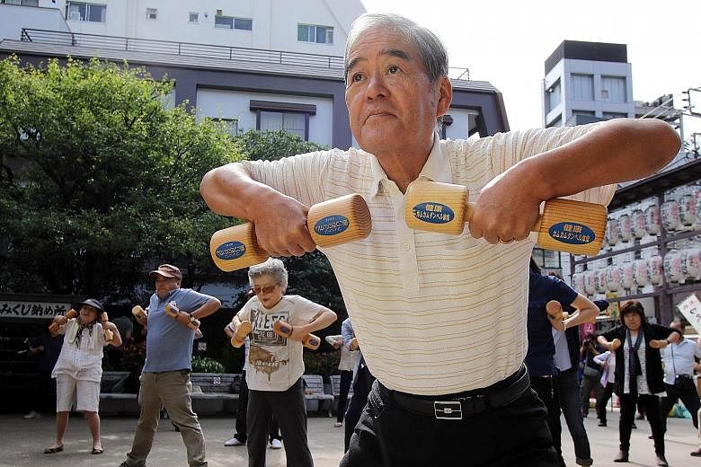 Elderly people working out on the grounds of a temple in Tokyo on Sept 21 to celebrate Japan's Respect for the Aged Day. Japan's working-age population started to shrink in 1997, weighing on the nation's output growth year after year.