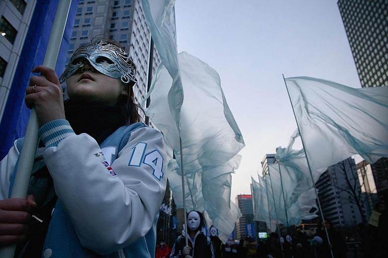 Hundreds taking part in the rally wore masks yesterday to protest against a proposed ban on masks at demonstrations after President Park Geun Hye compared masked protesters to ISIS terrorists.