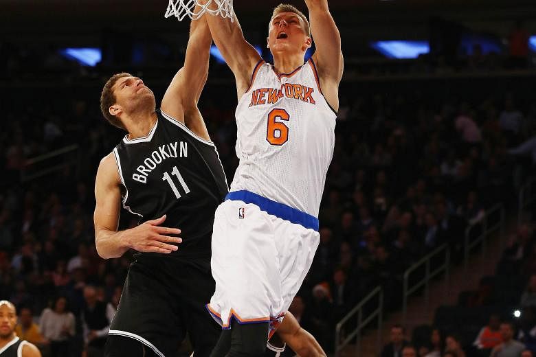 Kristaps Porzingis (No. 6) has no hesitation going for a dunk even as Brooklyn Nets' Brook Lopez tries to block his effort.