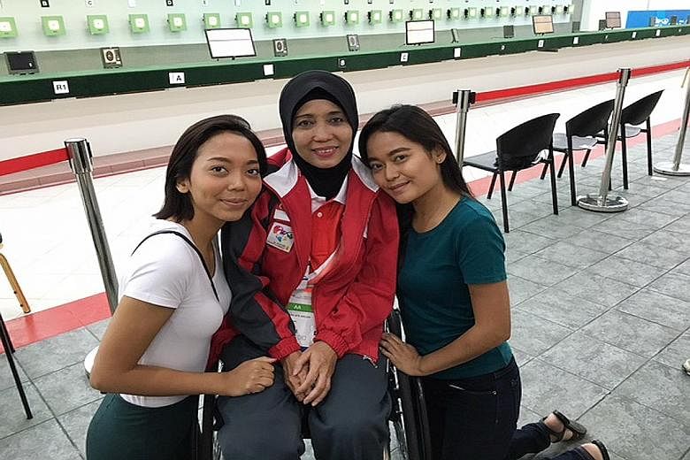 Dhamirah (in white) and Farhana with their mother Faridah, who is competing in shooting at the Asean Para Games, after pursuing the sport for only nine months.