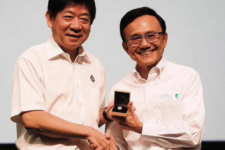 Mr Lim Joo Kwan (right in photo), one of three recipients of the Dedicated Service Star, receiving his award from Coordinating Minister for Infrastructure and Minister for Transport Khaw Boon Wan at the awards ceremony yesterday.