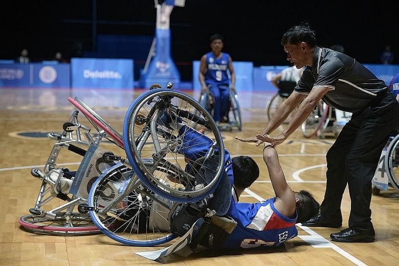 An official tends to Paphatsalang Khammany of Laos and John Rey Aguirre Escalante (in blue) of the Philippines after they collided during their match yesterday. The Philippines won a spirited encounter 61-55.