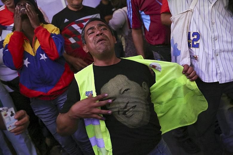 Supporters of Venezuela's defeated government, including this man wearing a T-shirt with an image of the late socialist president Hugo Chavez, were left distraught by the election result.