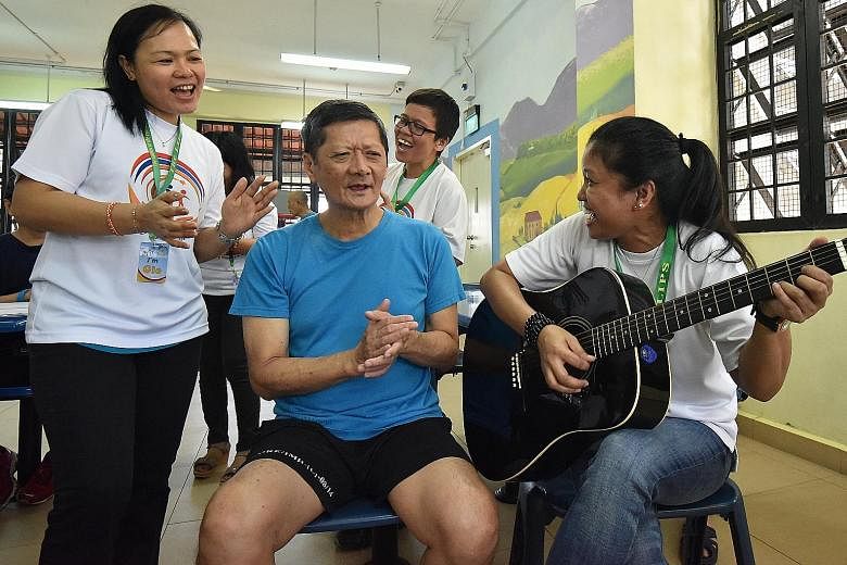 Mr Chua, an IMH patient, enjoying a singing session with volunteers (from left) Margie Agustin, 41, Agnes Juagpao, 41, and Priscilla Manangola, 36. He says he looks forward to the visit from members of the Ladies in the Power of Service volunteer gro