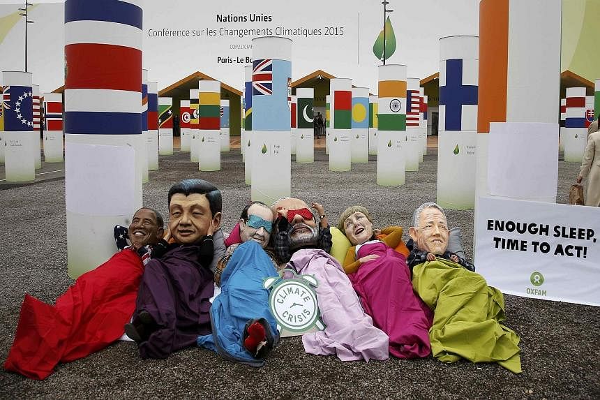 Activists from anti-poverty charity Oxfam protesting outside the talks venue while wearing masks depicting (from left) US President Barack Obama, Chinese President Xi Jinping, French President Francois Hollande, India's Prime Minister Narendra Modi, 
