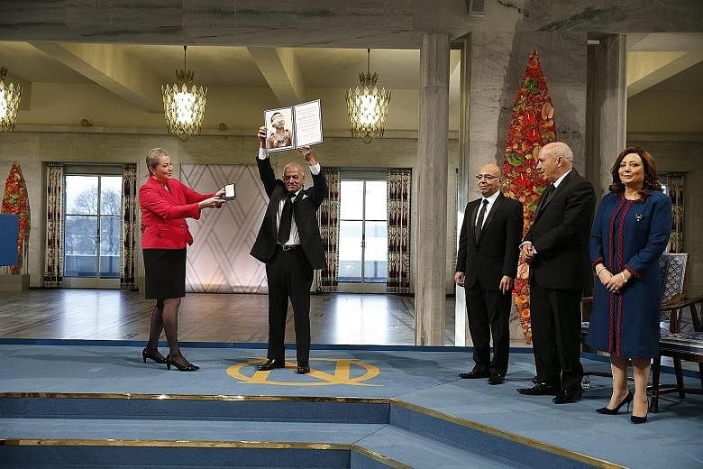 Ms Kaci Kullmann Five (in red) presenting the diploma and medallion to the winners of the 2015 Nobel Prize, the Tunisian National Dialogue Quartet. Representing the organisations in the quartet are (from left) General Labour Union secretary-general H