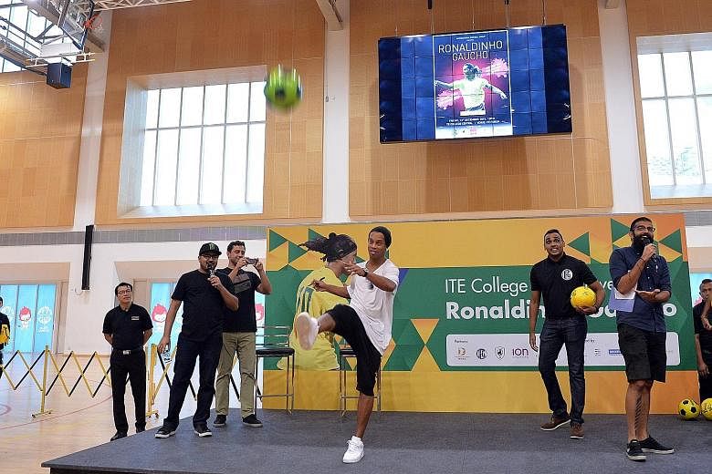 Ronaldinho kicking an autographed football into the capacity crowd at ITE College Central's multi-purpose hall during his 15-minute appearance yesterday.