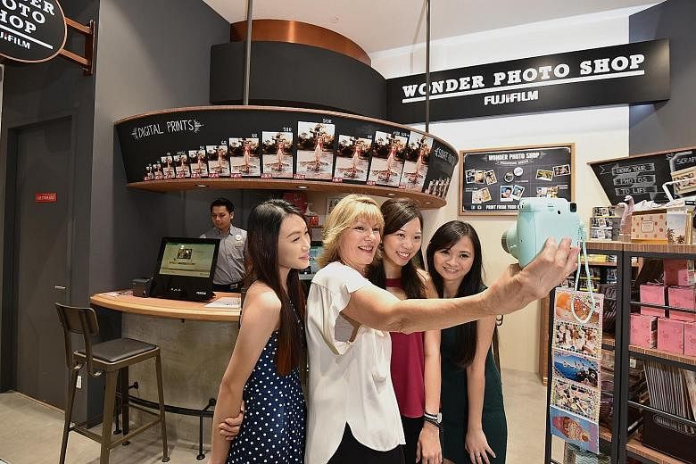 Harvey Norman chief executive Katie Page (second from left) posing for a wefie on Thursday with staff (from left) Gina Chan, Samantha Wong and Fiona Low at Singapore's first Fujifilm Wonder Photo Shop in the new Harvey Norman store in Millenia Walk.