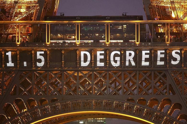 The climate deal target of "1.5 degrees" is projected on the Eiffel Tower. It refers to the aim of all participating nations to pursue efforts to limit global temperature increase to 1.5 deg C above pre-industrial levels.